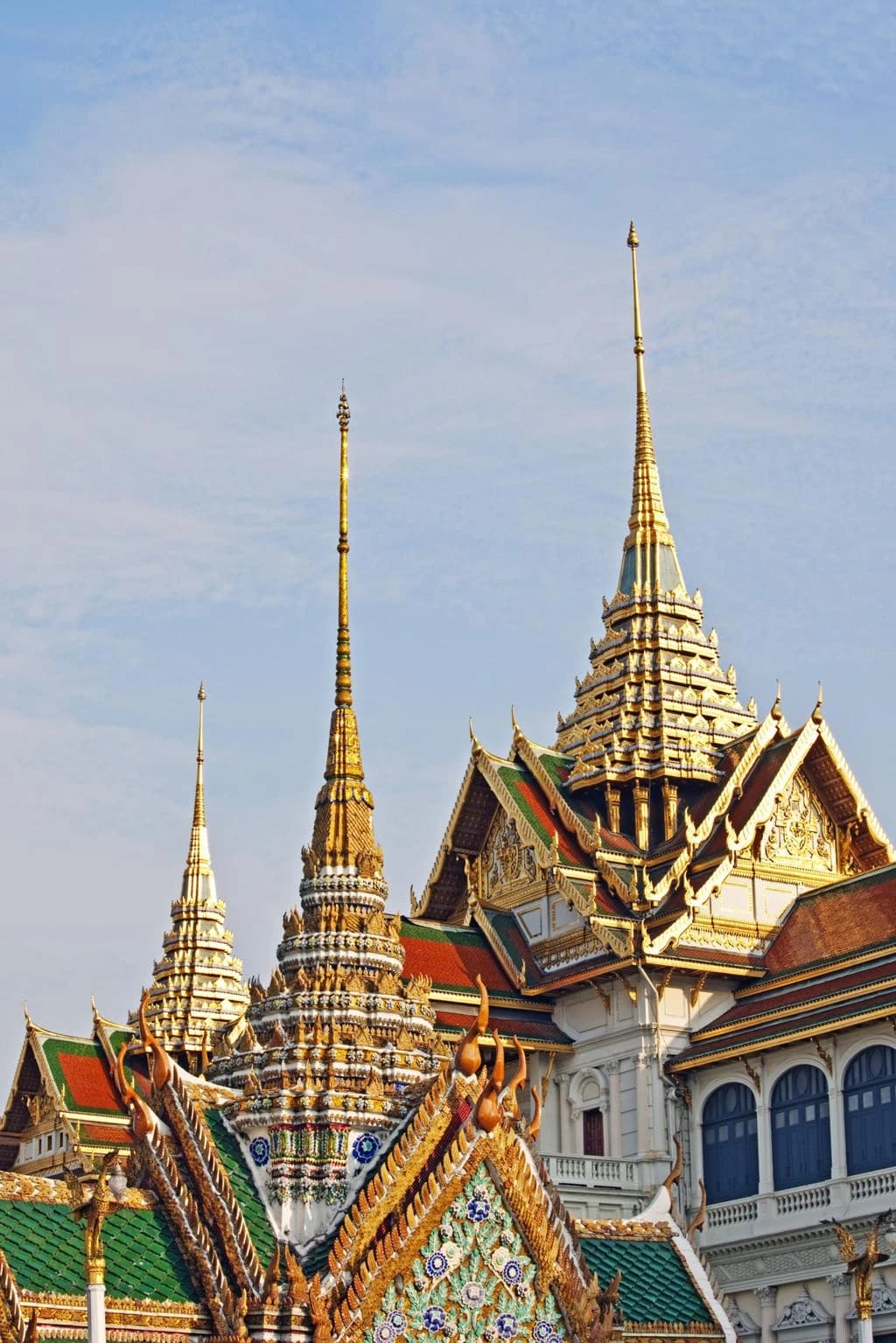 Daylight view of Wat Phra Kaew's layered roofs and golden spires