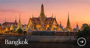 The Grand Palace in Bangkok beneath a warm evening sky